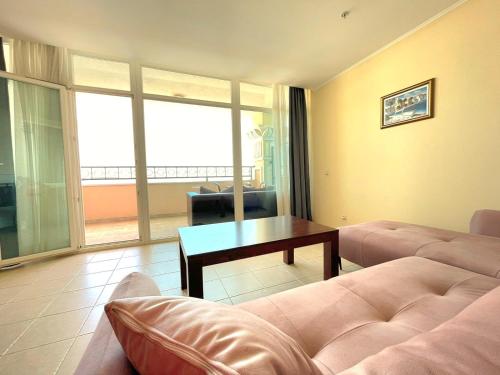 a living room with a couch and a table at "Красавиците тъмнокоси" Sunset Resort Pomorie in Pomorie
