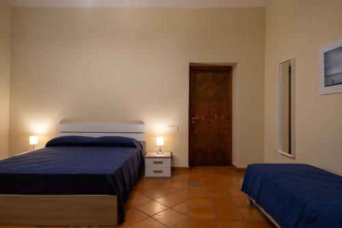 a bedroom with two beds and a door in it at Villa Marina in Cava deʼ Tirreni