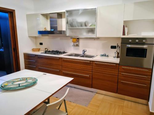 a kitchen with wooden cabinets and a sink and a table at Diamante 46, Appartamento per vacanza in Diamante