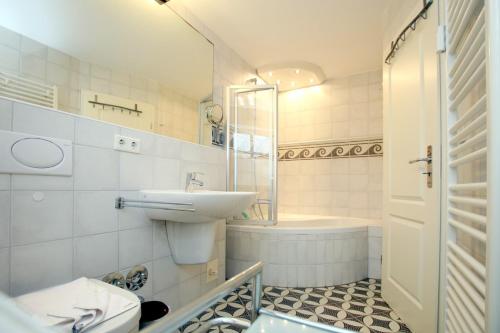 łazienka z umywalką, toaletą i wanną w obiekcie Stockmannsweg 11b_ Whg_ 1 w mieście Wyk auf Föhr