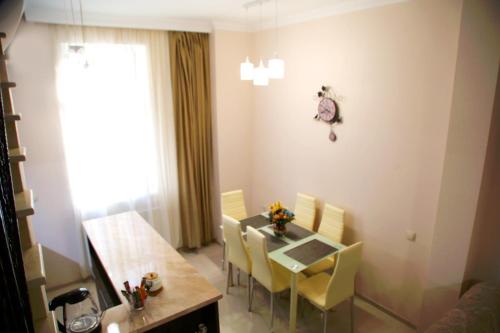 ein Esszimmer mit einem Tisch und gelben Stühlen in der Unterkunft Family apartments in Tbilisi City
