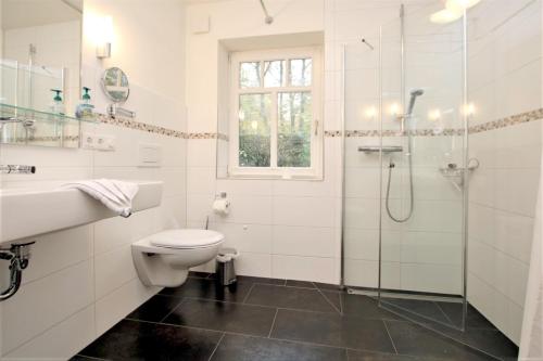 ein Bad mit einem Waschbecken, einem WC und einer Dusche in der Unterkunft Starklef 34a, Whg. 1, Huus Starklef in Wyk auf Föhr
