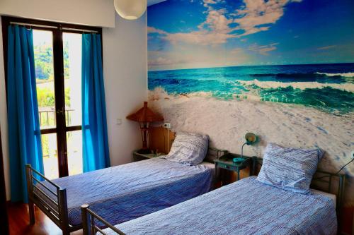 a bedroom with two beds and a mural of the ocean at Albergue Puente para peregrinos in Puente la Reina