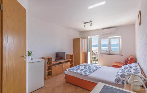ein kleines Schlafzimmer mit einem Bett und einem TV in der Unterkunft Cozy Apartment In Podaca With House Sea View in Podaca