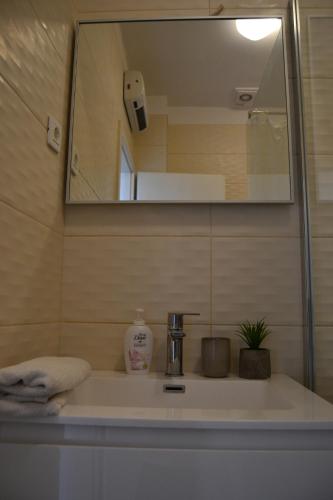 a bathroom with a sink and a mirror at Cherry in Korčula