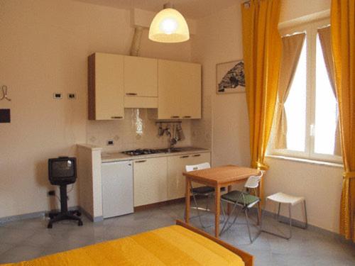a kitchen with white cabinets and a table and chairs at Excelsior Mare Suite in Ischia