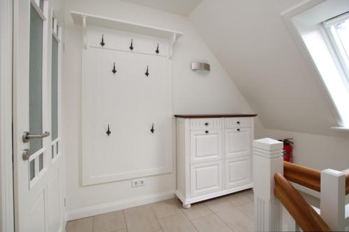een witte kamer met een trap met een witte kast bij Starklef 34a_ Whg_ 2_ Huus Starklef in Wyk auf Föhr
