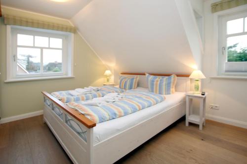 een groot wit bed in een kamer met 2 ramen bij Starklef 34a_ Whg_ 2_ Huus Starklef in Wyk auf Föhr