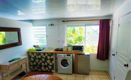 une cuisine avec un lave-linge et une fenêtre dans l'établissement RAIATEA - Studio Tenape, à Tevaitoa