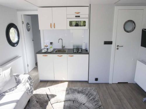 a kitchen with white cabinets and a sink at Rantakatti Apartments in Punkaharju