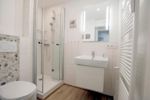 een witte badkamer met een toilet en een wastafel bij Am Flugplatz 7_ Haus Habel Whg_ 12 in Wyk auf Föhr