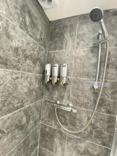 a shower with a shower head in a bathroom at Modern 2 bedroom apartment, with car parking. in Oldland Common