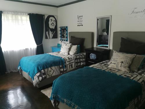 sypialnia z 2 łóżkami i lustrem w obiekcie VESA Guesthouse w mieście Meyerton