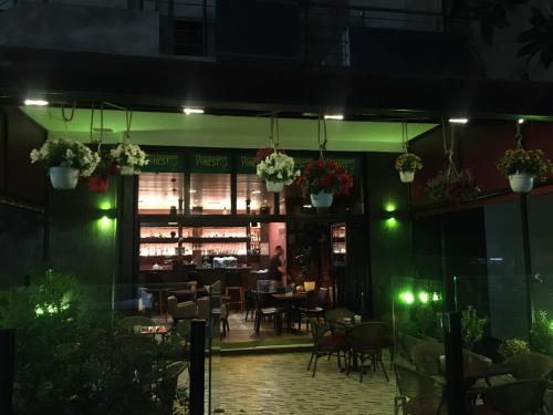 a restaurant with tables and chairs at night at Jordan`s Hotel in Vlorë