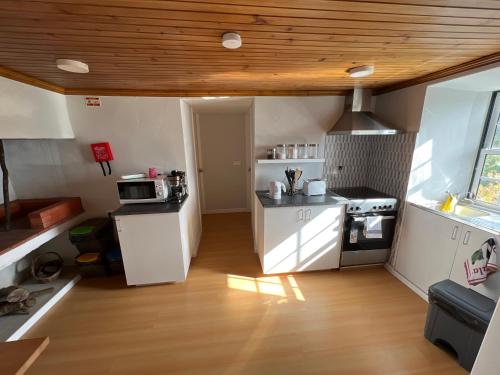 a kitchen with white appliances and a wooden ceiling at Rosa do Canto in Monte