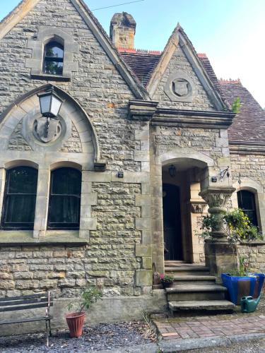 an old stone house with a front door and stairs at South Lodge House in Dormans Land