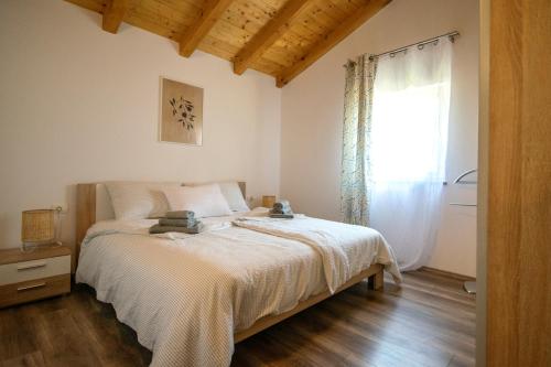 a bedroom with a bed and a window at Old Oak Holiday House in Rovinj
