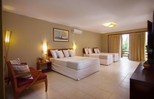 a hotel room with two beds and a couch at La Torre Resort All Inclusive in Porto Seguro