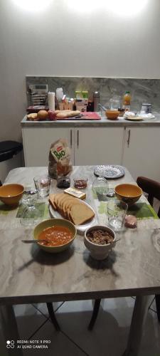 ein Tisch mit Schüsseln mit Essen in einer Küche in der Unterkunft Les plaisirs de la ruralité in Vendresse