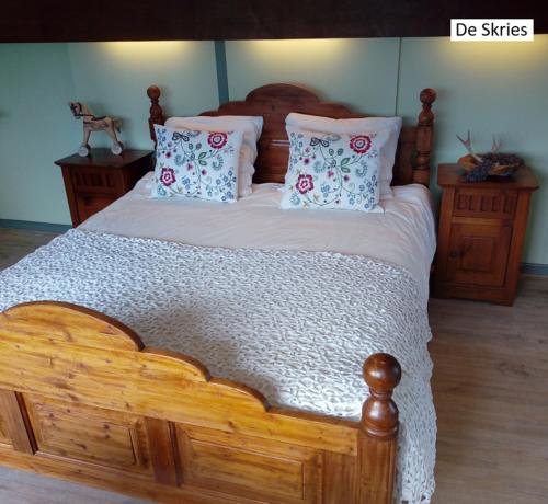 a wooden bed with pillows on it in a bedroom at B&B De Flecht - De Skries in Nijega