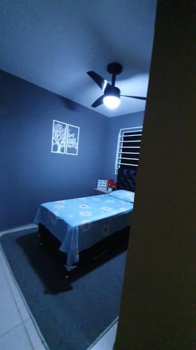 a blue bedroom with a bed and a ceiling fan at Bedroom Airport in Maceió