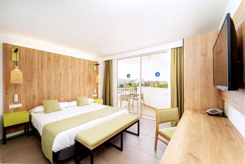 a hotel room with a bed and a balcony at Ibersol Siurell in Sa Coma