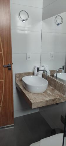a bathroom with a white sink and a mirror at Hotel Esmeralda Verde in Teófilo Otoni