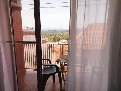 Habitación con vistas a un balcón con mesa y silla. en Precioso aptmento en Gilet a pies de la Calderona, en Gilet