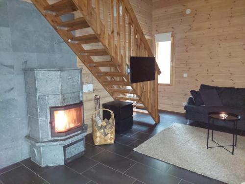 uma sala de estar com lareira e sofá em Kantokelo B2 em Ylläsjärvi