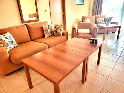 a living room with a couch and a coffee table at "Красавиците тъмнокоси" Sunset Resort Pomorie in Pomorie