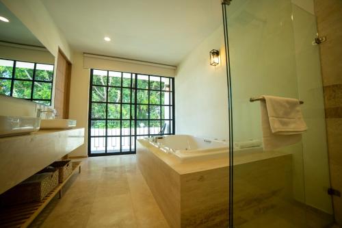 La salle de bains est pourvue d'une baignoire et d'une douche en verre. dans l'établissement Hotel Dex Tlaquepaque, à Guadalajara