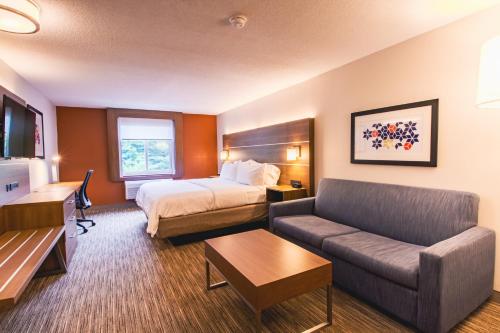 a hotel room with a bed and a couch at Holiday Inn Express & Suites - Lincoln East - White Mountains by IHG in Lincoln