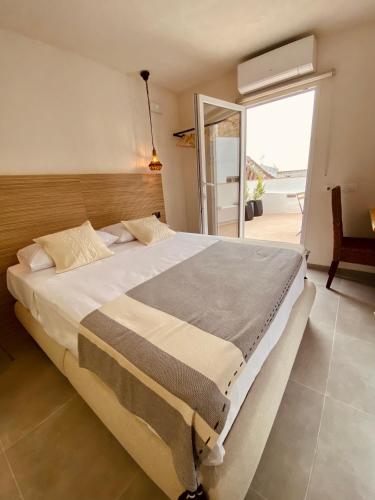 a bedroom with a large bed and a balcony at VICTORIA - by Ático73 in Medina Sidonia