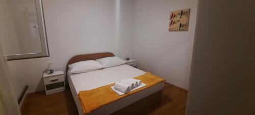 ein kleines Schlafzimmer mit einem Bett mit einer gelben Decke in der Unterkunft Apartment Elena in Galovac
