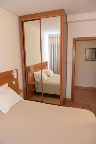 a bedroom with two beds and a large mirror at Casa Das Eiras in Macedo de Cavaleiros