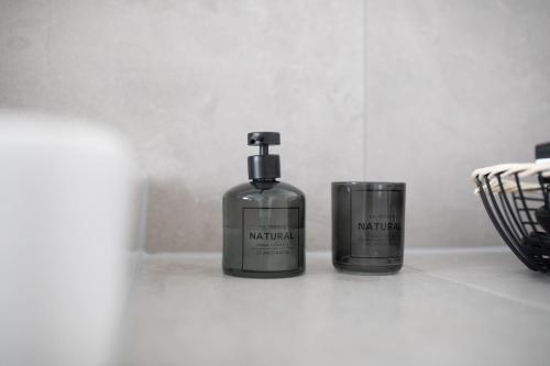two bottles of soap sitting on a bathroom counter at Küsten Suite Nord - direkte Wasserlage, Terrasse, 70qm in Greetsiel