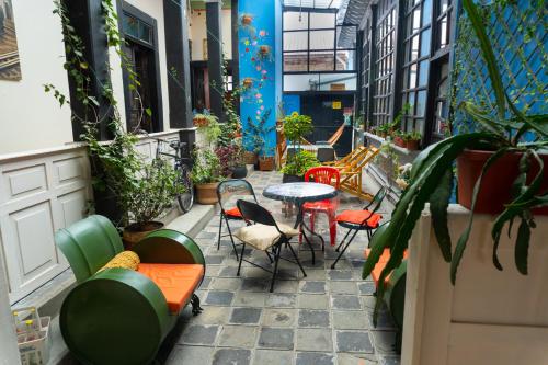 a patio with a table and chairs and plants at Villa Bonita Hostel in Riobamba