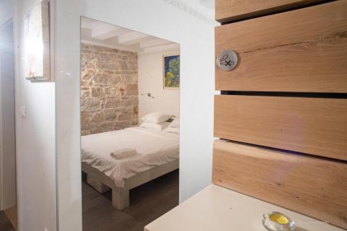 sypialnia z łóżkiem i ceglaną ścianą w obiekcie Nata Apartment 4 stars w Rovinj