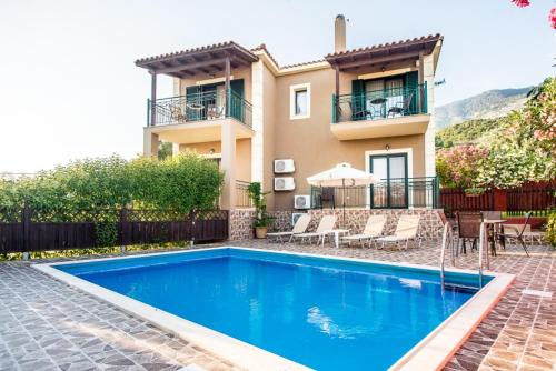 uma casa com piscina em frente a uma casa em Villa Nefeli em Trapezaki
