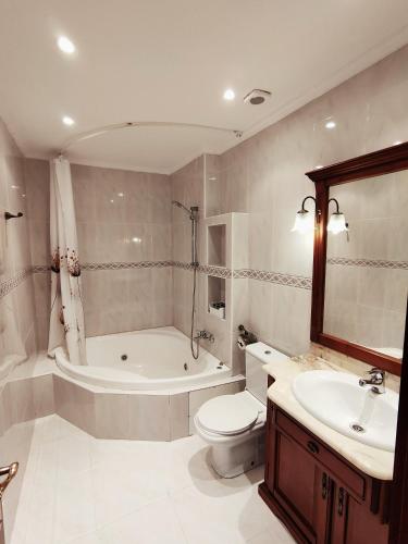 a bathroom with a tub and a toilet and a sink at BAKEA in Bermeo