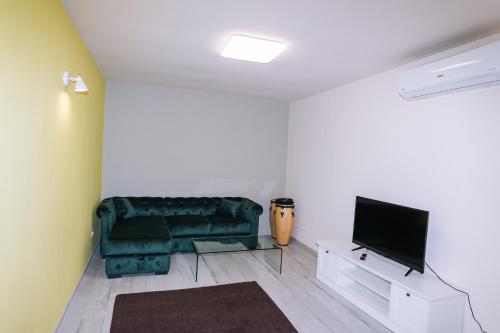 een woonkamer met een groene bank en een tv bij The Home in Timişoara