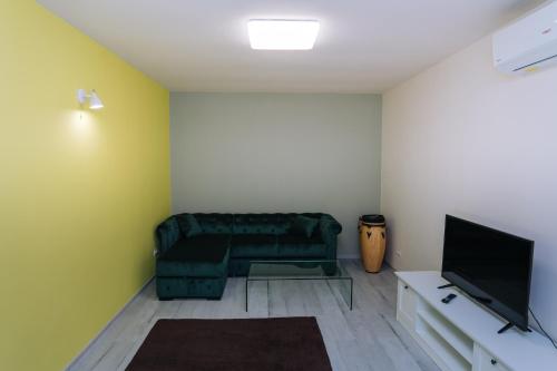 a living room with a couch and a television at The Home in Timişoara