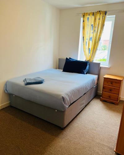 a bedroom with a large bed with a window at MODERN 2bed 2bath Ground Floor Apartment in Edinburgh
