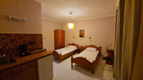 a room with two beds and a kitchen with a sink at Garden City Image in Tigaki