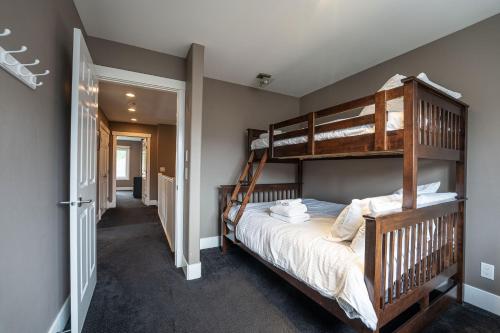 a bedroom with two bunk beds and a hallway at Aspen Lodge by Revelstoke Vacations in Revelstoke