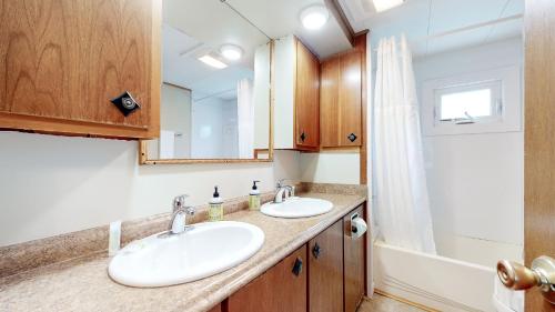 a bathroom with two sinks and a mirror at Riverbank's Pemi Cottage in Lincoln