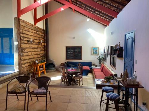 アイウルオカにあるPousada Lenda da Montanhaのリビングルーム(ソファ、テーブル、椅子付)