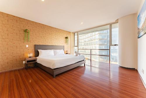 a bedroom with a bed and a large window at Antara apartments by VH in Mexico City