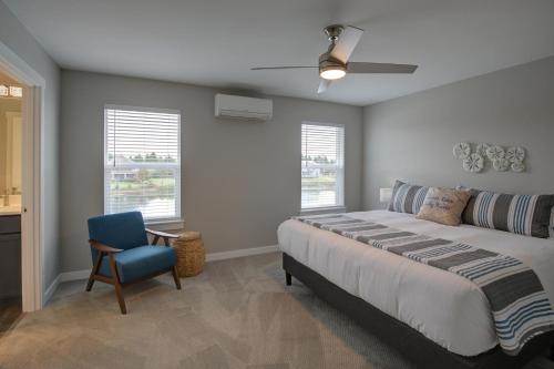 a bedroom with a large bed and a blue chair at Sea Swept Mermaid Oyhut Bay Seaside Village in Ocean Shores