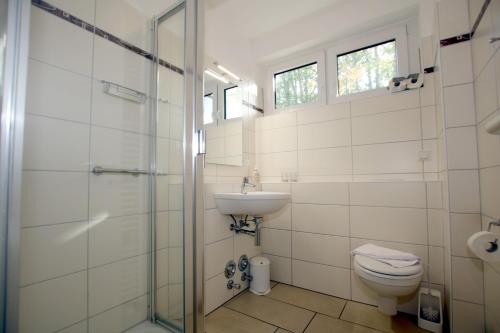 een badkamer met een toilet, een wastafel en een douche bij Waldstraße 19a, Whg 21, Feriendomizil am Südstrand in Wyk auf Föhr